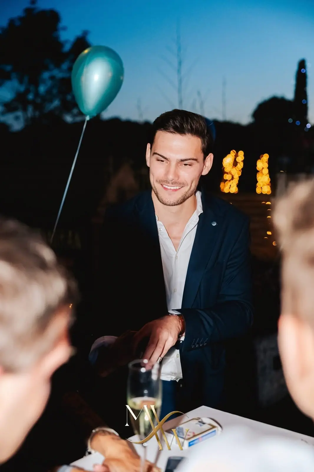 Gasten volgen aandachtig een kaarttruc tijdens een sfeervol avondfeest